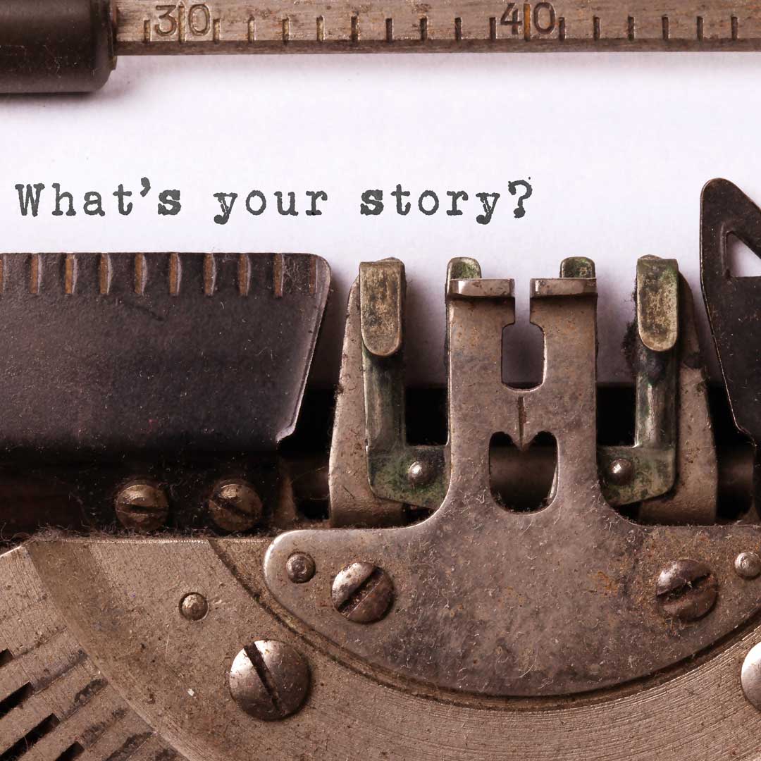 Schreibmaschine mit geschriebenem Text auf einem Blatt Papier "What's your story?"